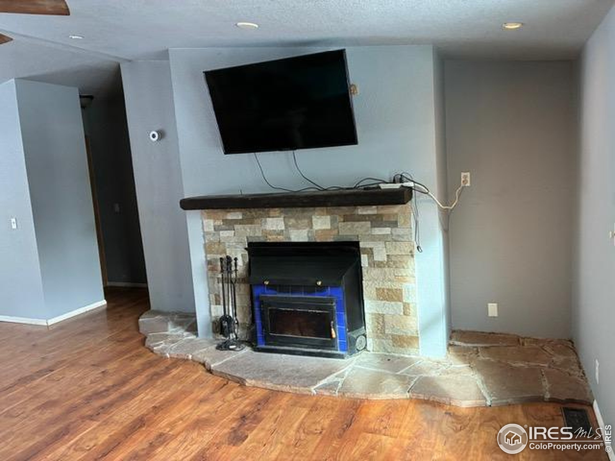 1759 Arapahoe Drive Florissant, CO 80816 - Photo 11 of 40 a living room with a fireplace and a flat screen tv