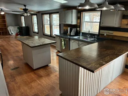 a kitchen with granite countertop a stove a sink and a dining table
