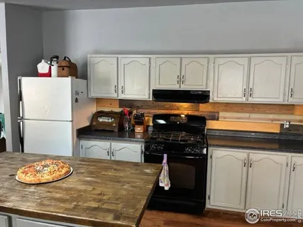 a kitchen with a refrigerator and a stove top oven
