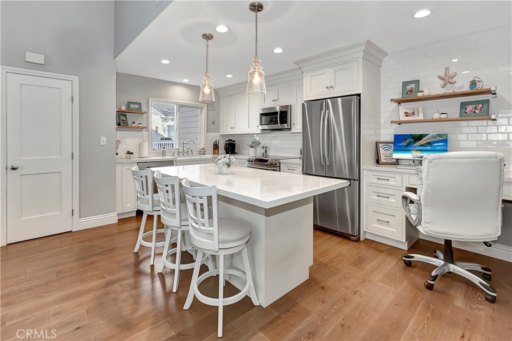 a kitchen with kitchen island white cabinets and stainless steel appliances