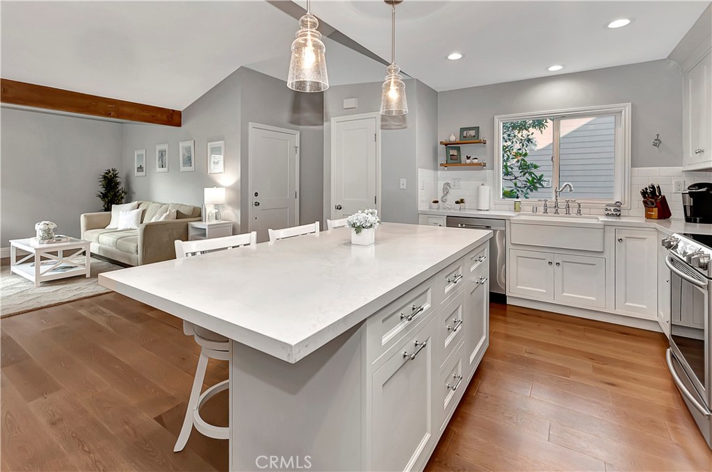 34014 Selva Road, Unit 19 Dana Point, CA 92629 - Photo 9 of 19 a large white kitchen with a sink a stove and chairs