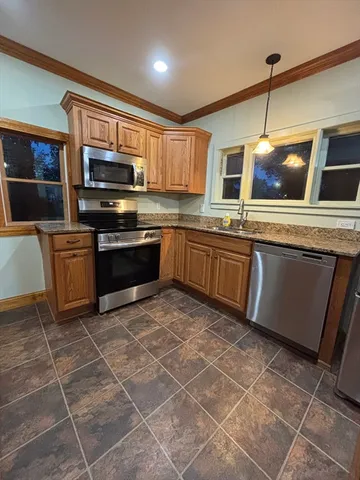 a kitchen with stainless steel appliances a stove a sink a microwave and refrigerator