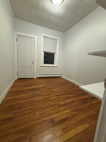 a view of an empty room with wooden floor