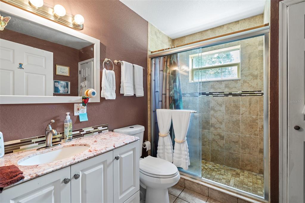 2830 Horton Road Kissimmee, FL 34744 - Photo 19 of 35 a bathroom with a granite countertop sink toilet and shower