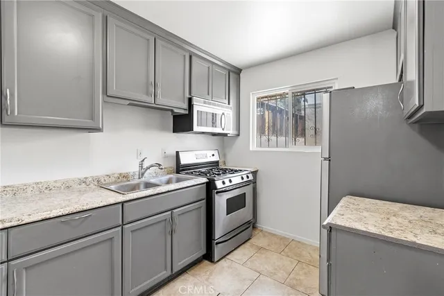 a kitchen with stainless steel appliances granite countertop a sink stove and cabinets