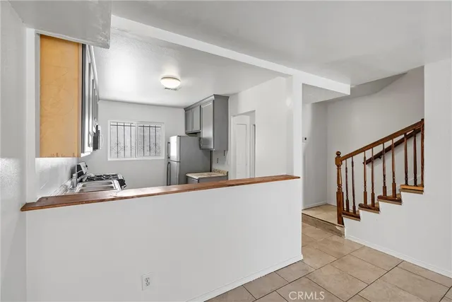 a hallway with a large window and a refrigerator