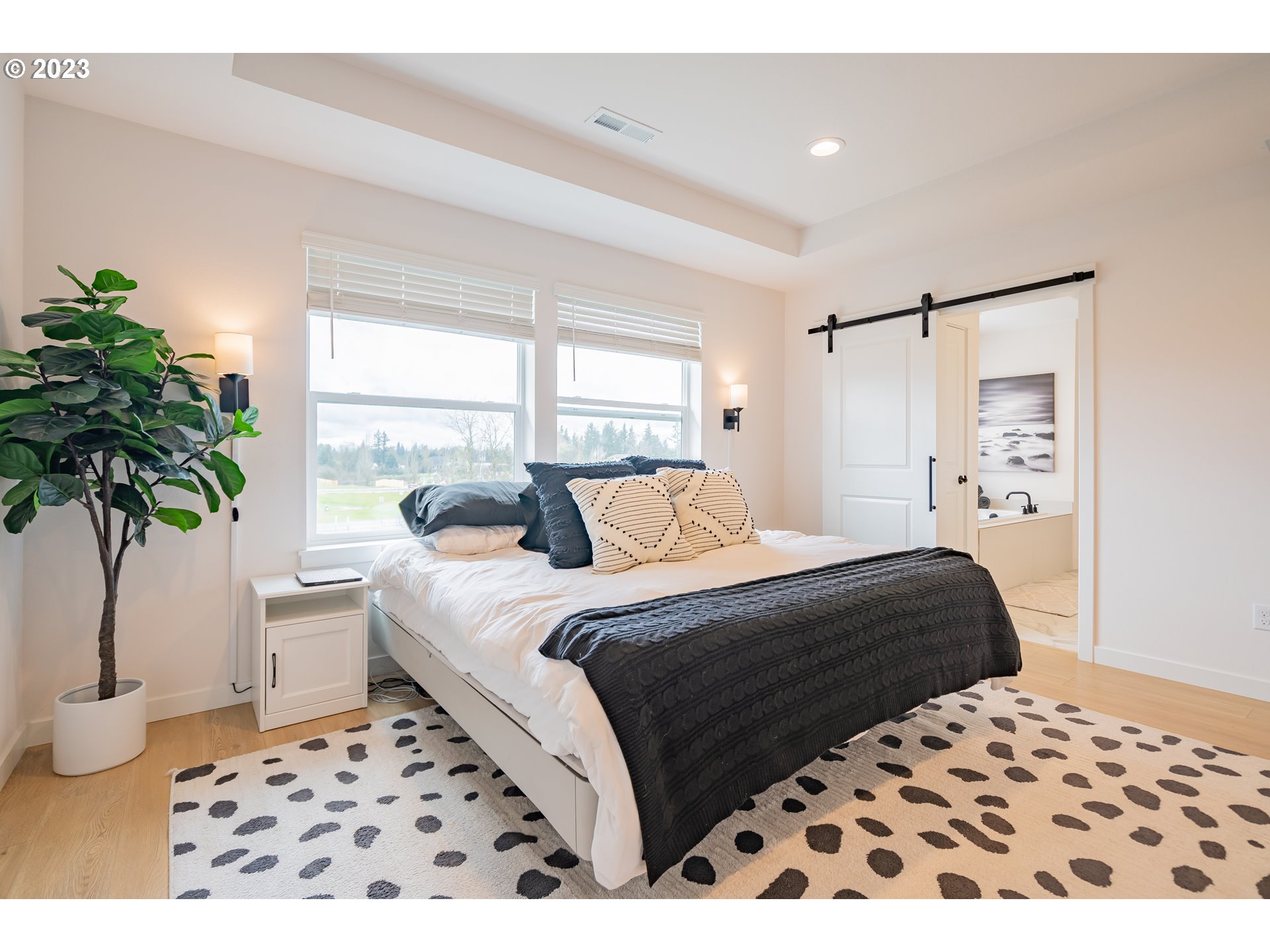 8719 North 1st Street Ridgefield, WA 98642 - Photo 36 of 45 a bedroom with a large bed and a potted plant