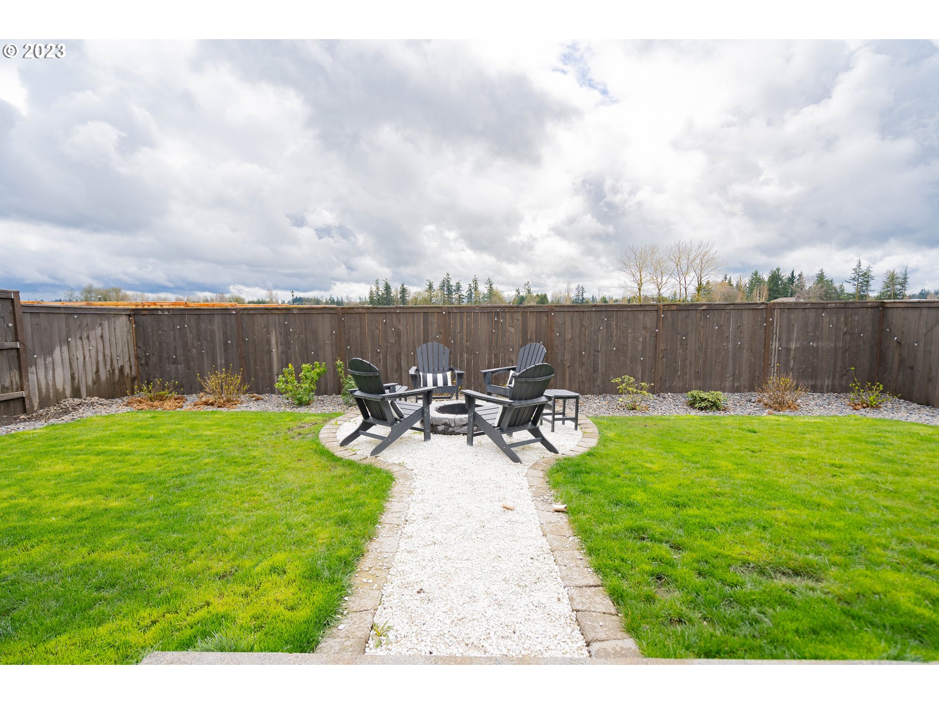 8719 North 1st Street Ridgefield, WA 98642 - Photo 44 of 45 a view of a lake with table and chairs potted plants and lake view