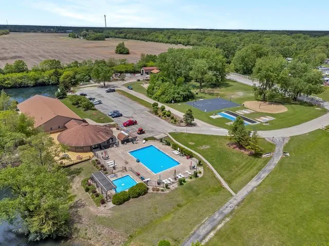 an aerial view of a house with a garden and lake view