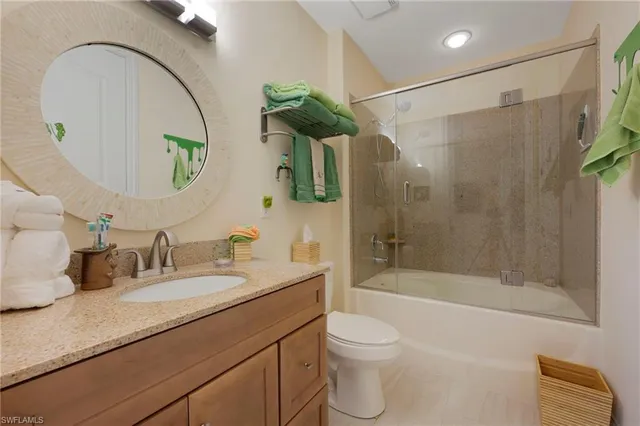 a bathroom with a granite countertop sink a toilet and shower
