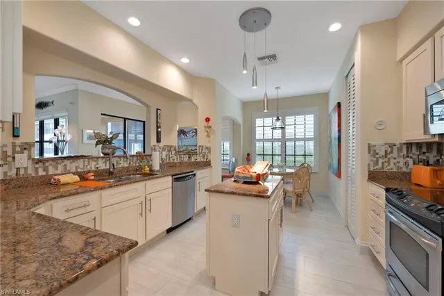 a kitchen with sink stove and chairs