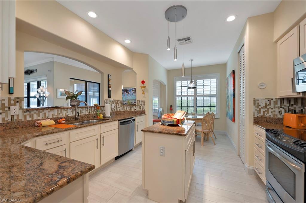 1299 Verde Drive, Unit 1503 Naples, FL 34105 - Photo 9 of 12 a kitchen with sink stove and chairs