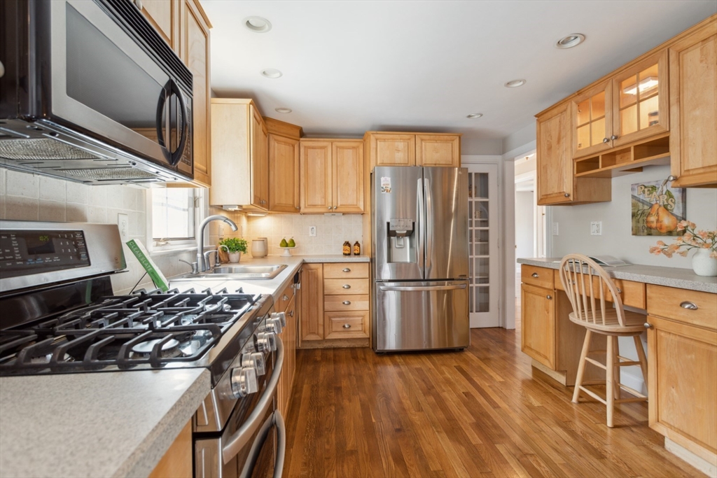 16 Meriam Street Wakefield, MA 01880 - Photo 15 of 42 a kitchen with stainless steel appliances a refrigerator a stove a sink dishwasher and wooden cabinets with wooden floor