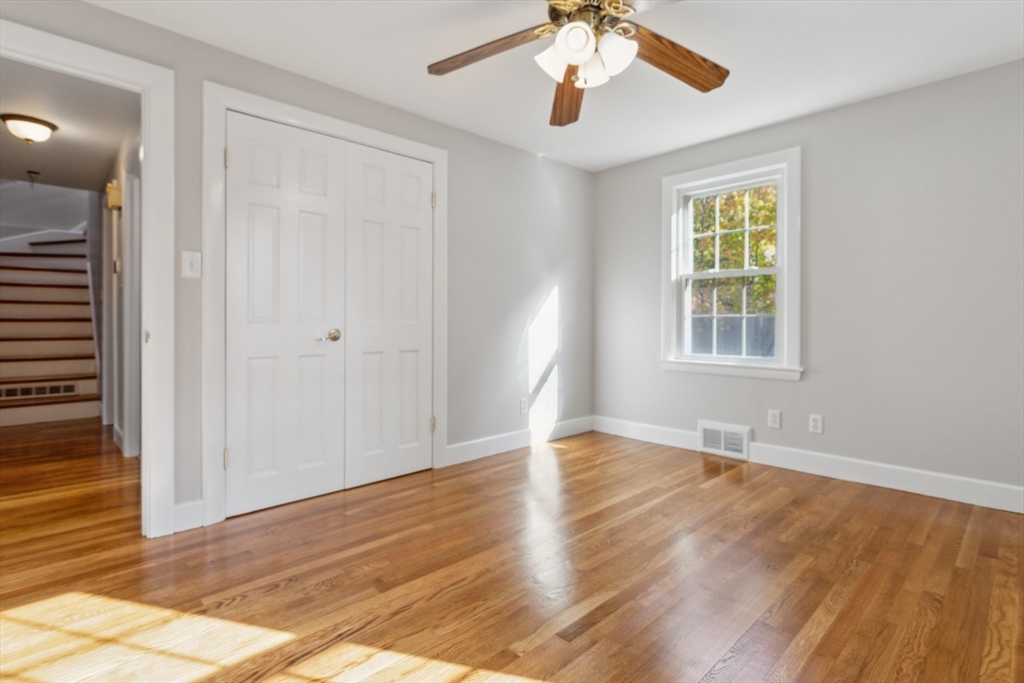 16 Meriam Street Wakefield, MA 01880 - Photo 16 of 42 an empty room with wooden floor chandelier fan and windows