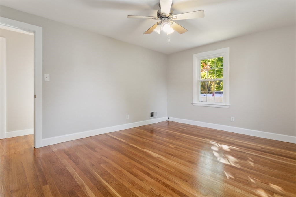 16 Meriam Street Wakefield, MA 01880 - Photo 21 of 42 an empty room with wooden floor chandelier fan and windows