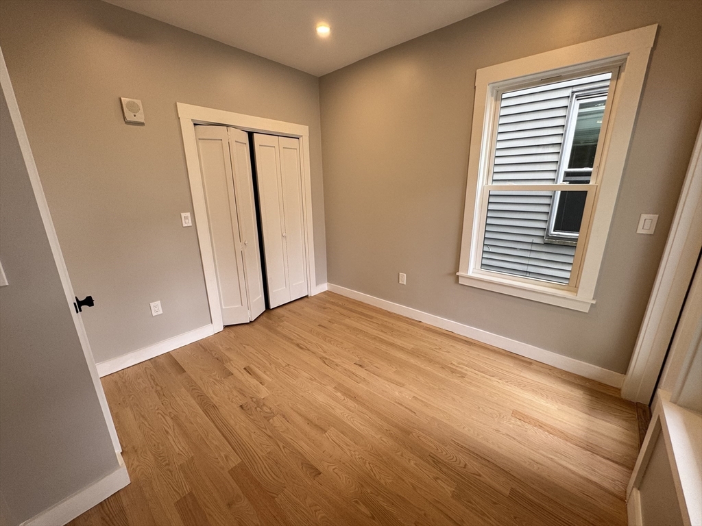 272 East Cottage Street, Unit 1 Boston, MA 02125 - Photo 7 of 10 a view of an empty room with wooden floor and a window