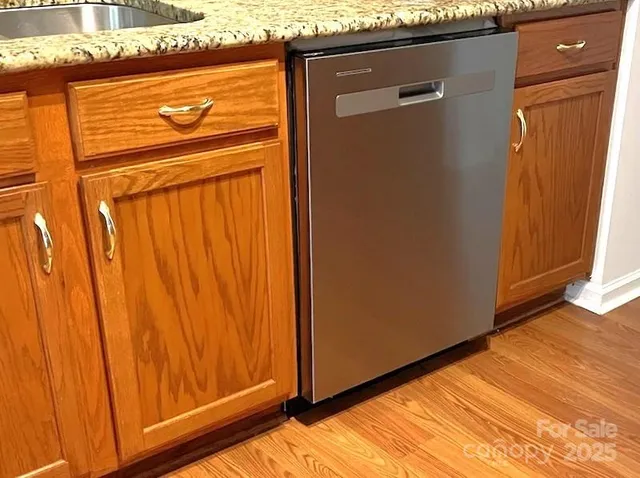 a kitchen with stainless steel appliances granite countertop wooden cabinets a sink and dishwasher