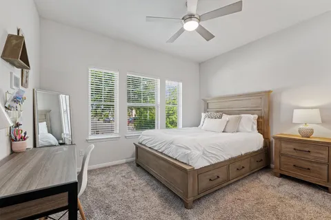 a bedroom with a bed a chandelier and a dresser