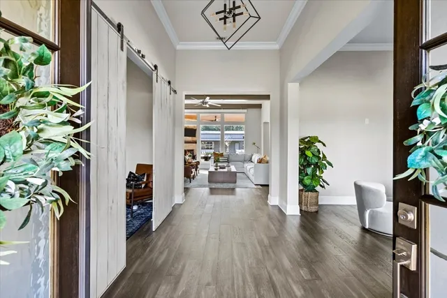 a hallway with wooden floor and a potted plant