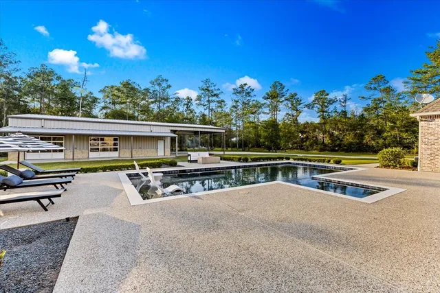 a view of a house with pool and chairs