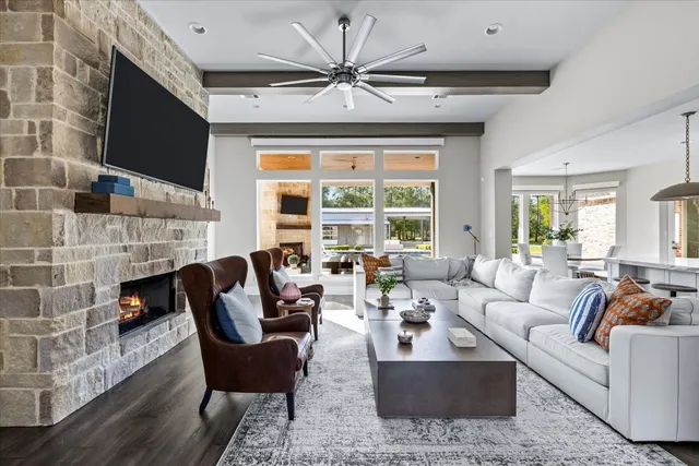 a living room with furniture a fireplace and a large window