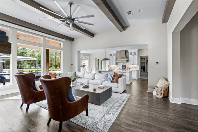a living room with furniture large window and wooden floor