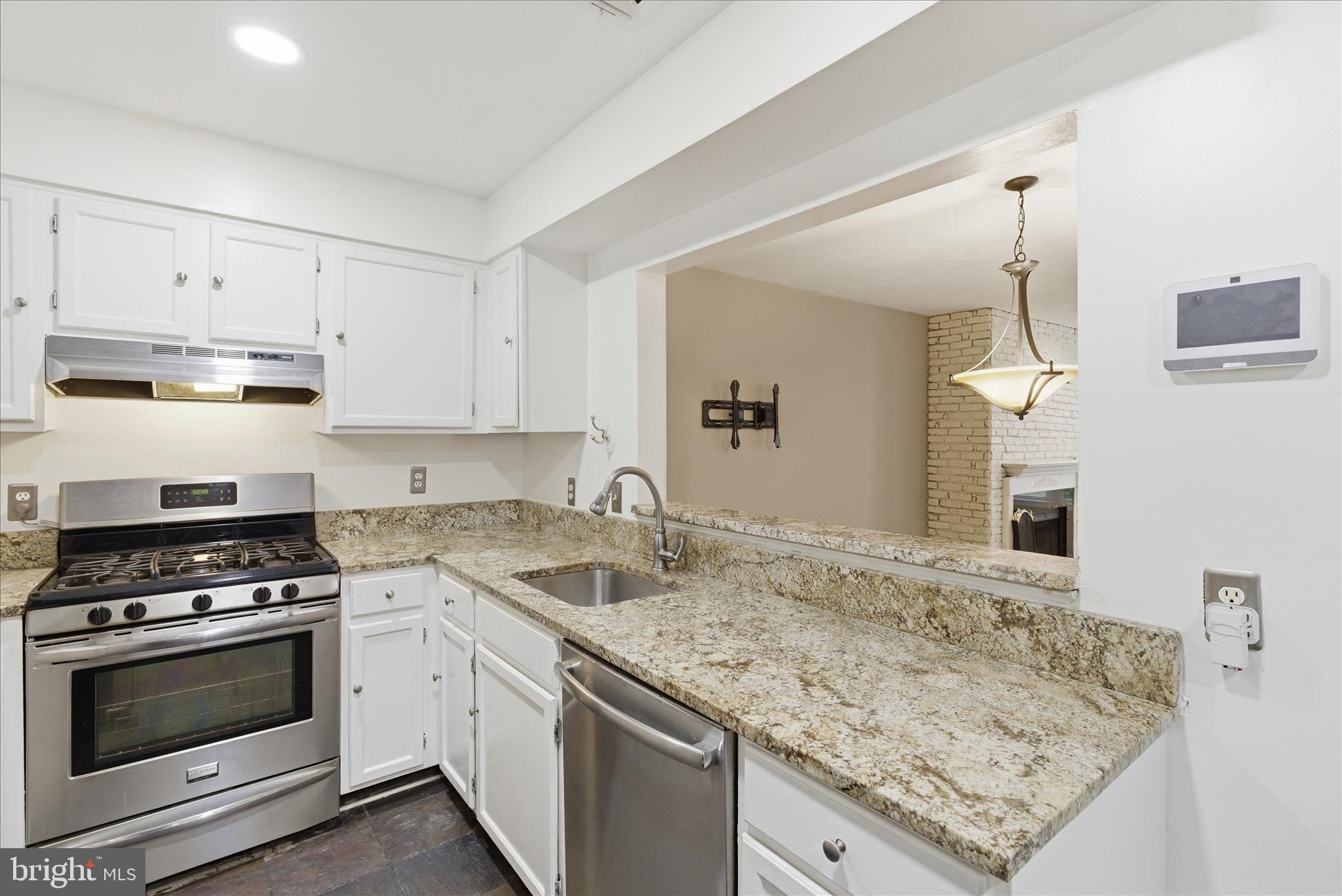 4167 Churchman Way Woodbridge, VA 22192 - Photo 16 of 36 a kitchen with granite countertop a sink stove and cabinets