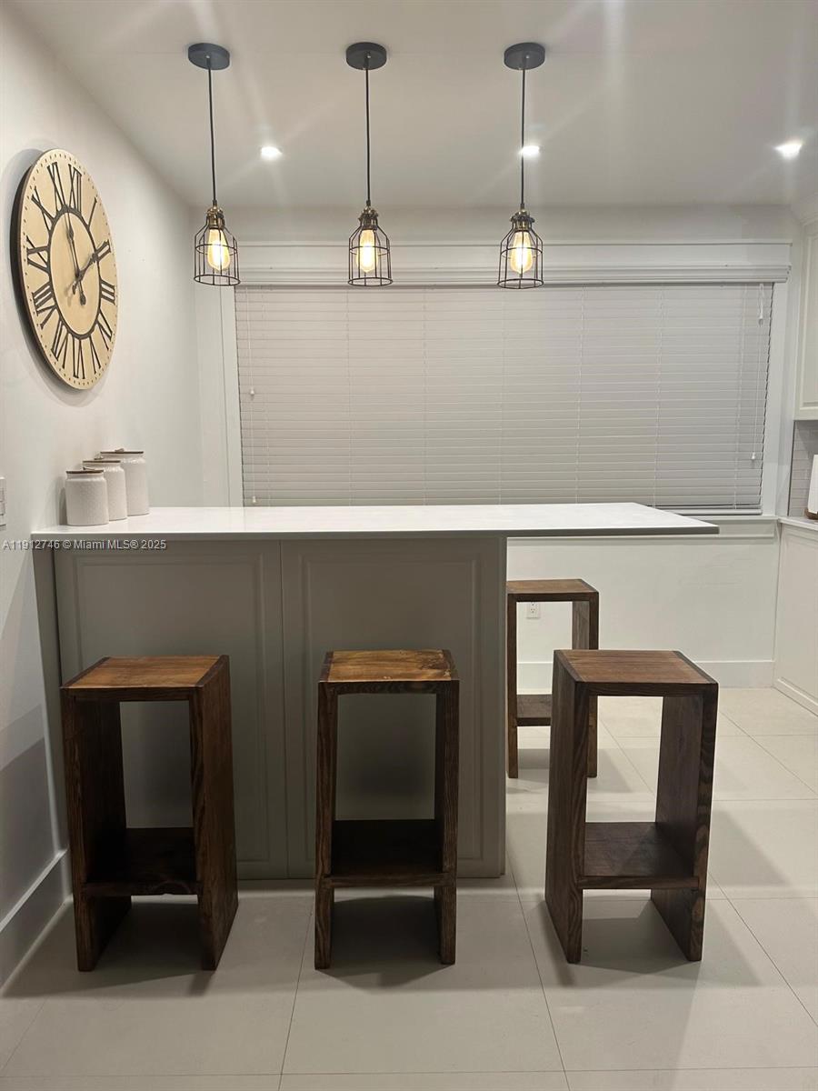 10040 Northwest 9th St Circle, Unit 202 Miami, FL 33172 - Photo 1 of 17 a hallway with a chair a lamp and a chandelier