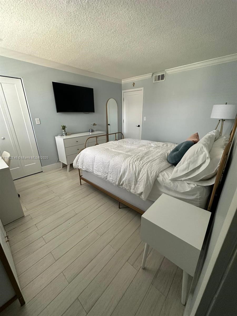 10040 Northwest 9th St Circle, Unit 202 Miami, FL 33172 - Photo 12 of 17 a bedroom with a bed and a flat screen tv