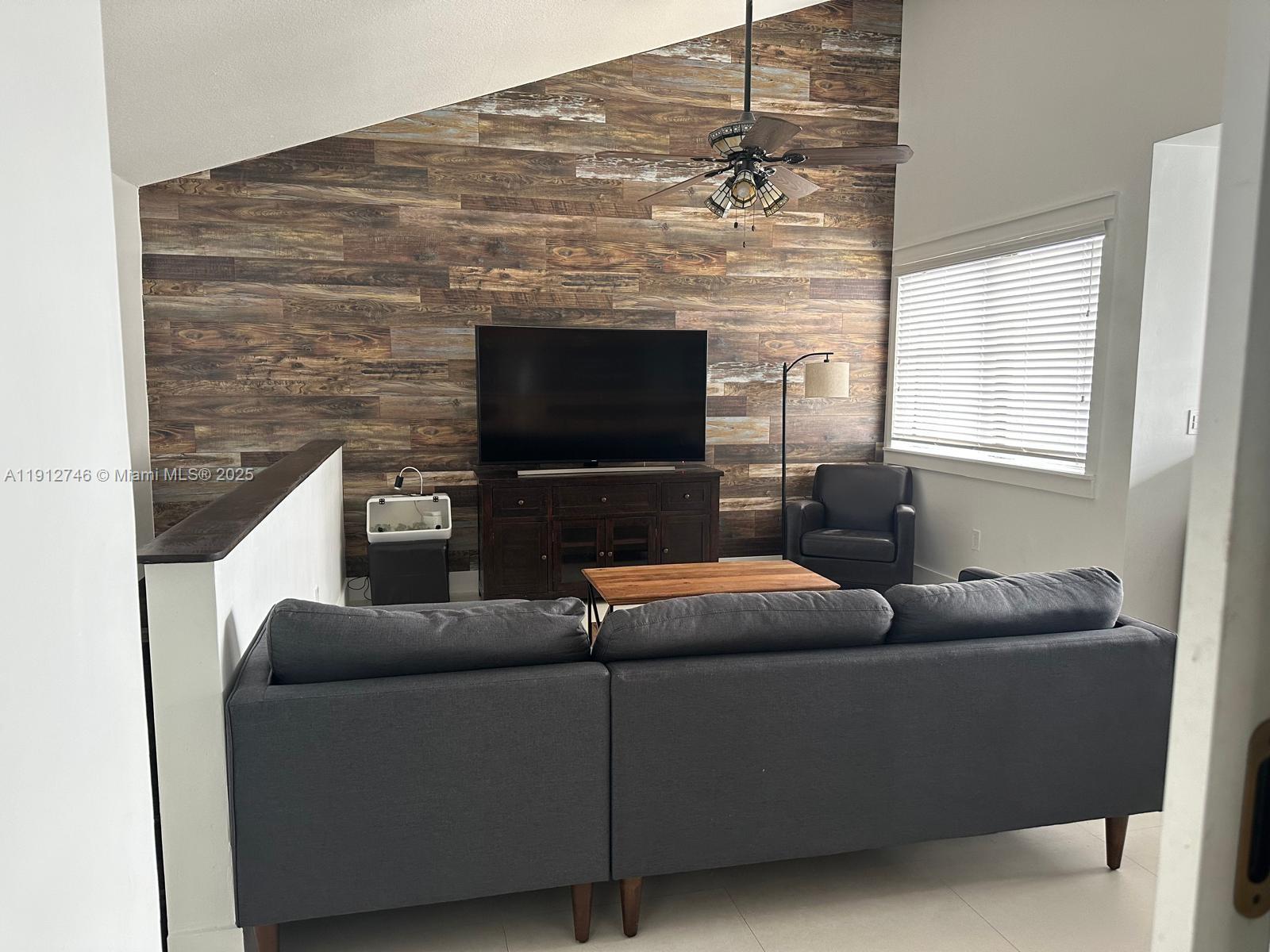 10040 Northwest 9th St Circle, Unit 202 Miami, FL 33172 - Photo 3 of 17 a living room with furniture and a flat screen tv