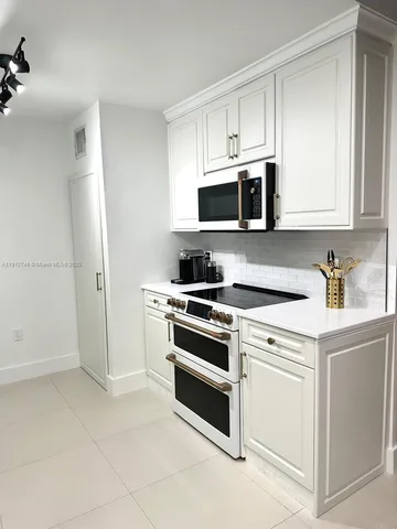 a kitchen with cabinets stainless steel appliances and sink