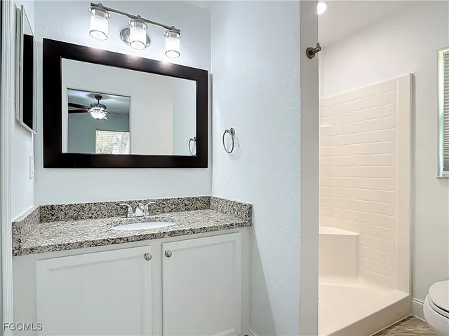a bathroom with a granite countertop sink vanity and mirror