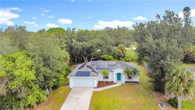 a view of a house with a big yard and large trees