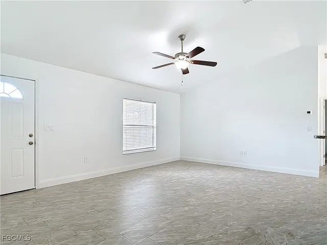 a view of room with hardwood floor and a ceiling fan