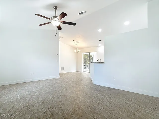 an empty room with a ceiling fan and window