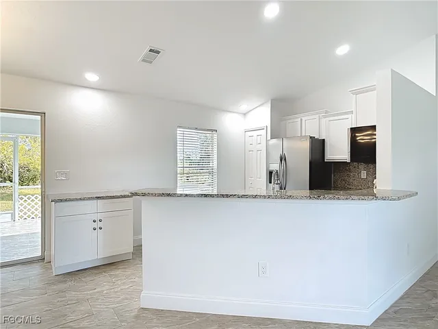 a view of a kitchen with stainless steel appliances wooden floor and a large window