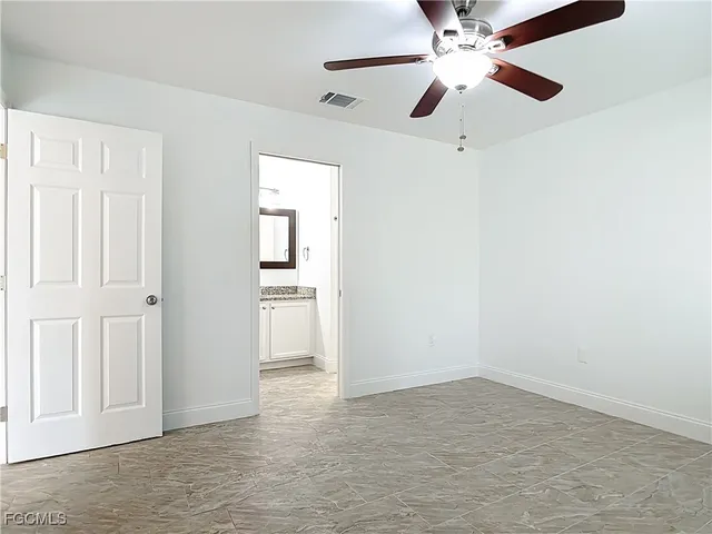 en empty room with ceiling fan and window