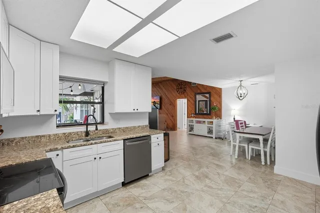 a kitchen with a refrigerator a stove and white cabinets
