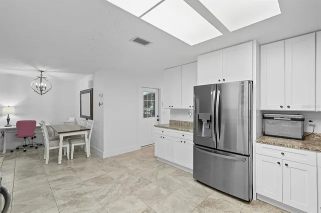 a kitchen with stainless steel appliances granite countertop a refrigerator stove a sink dishwasher and microwave oven