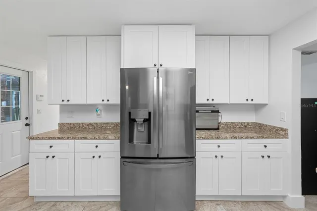 a kitchen with granite countertop a sink cabinets and stainless steel appliances