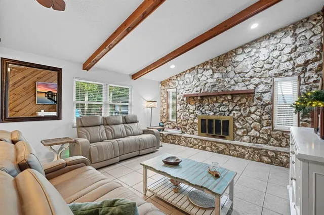 a living room with furniture a fireplace and a flat screen tv