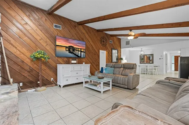 a view of a dining room with furniture a chandelier and a window