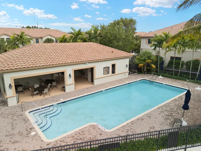 a view of a house with a backyard patio and swimming pool