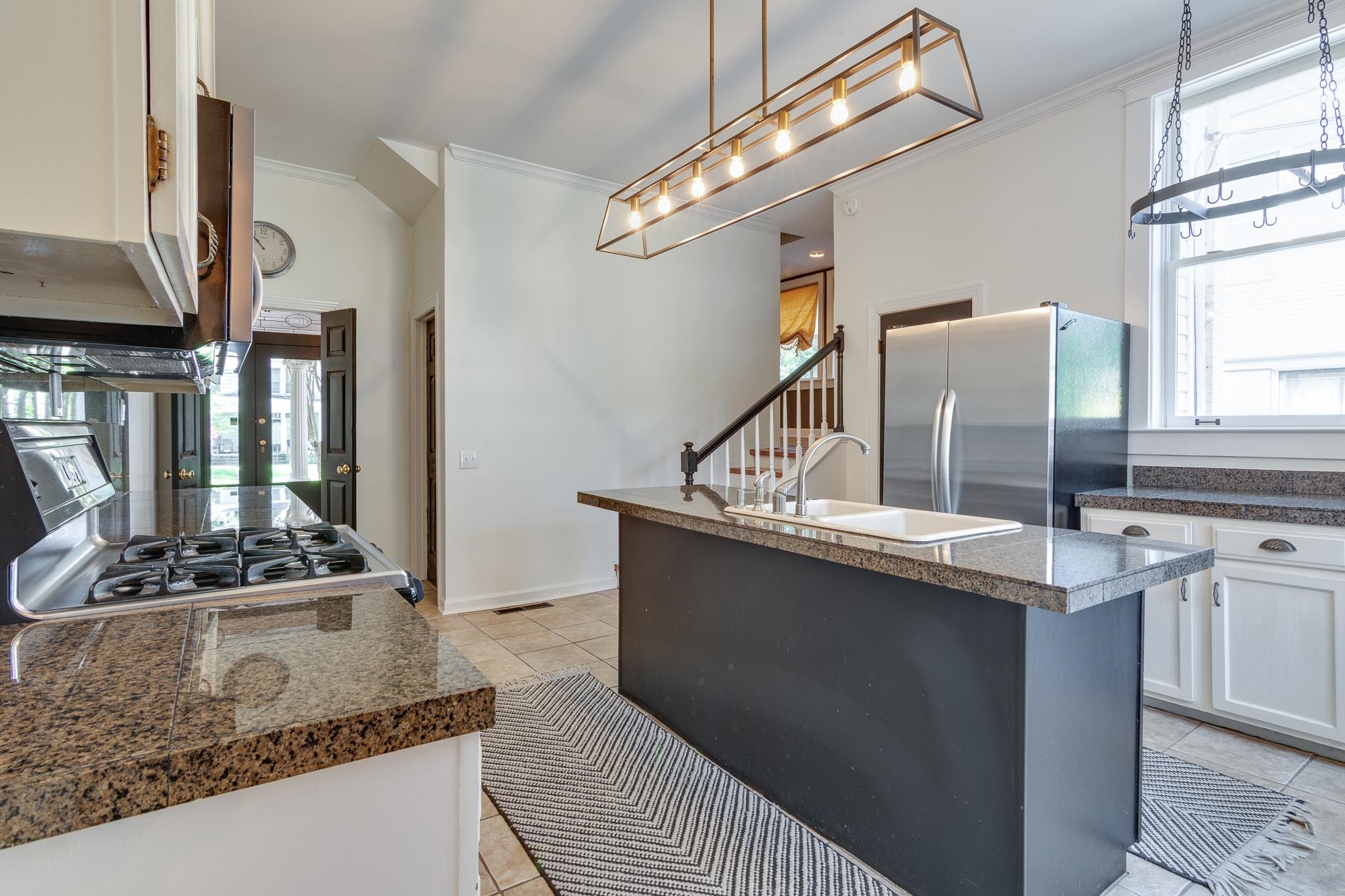 1680 Carruthers Place Memphis, TN 38112 - Photo 11 of 36 a kitchen with stainless steel appliances granite countertop a sink a stove and a refrigerator