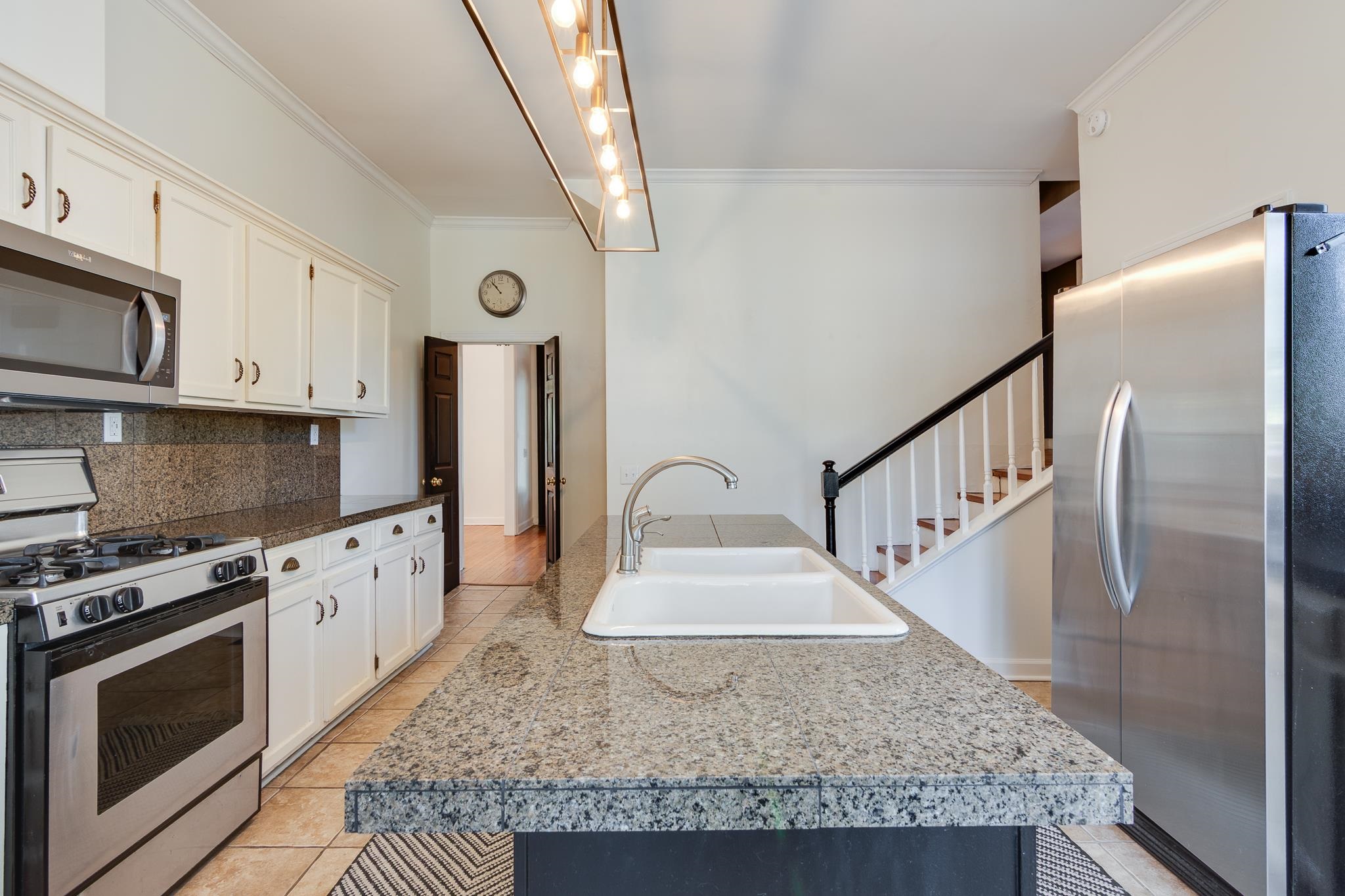 1680 Carruthers Place Memphis, TN 38112 - Photo 12 of 36 a kitchen with stainless steel appliances granite countertop a stove a sink and a microwave