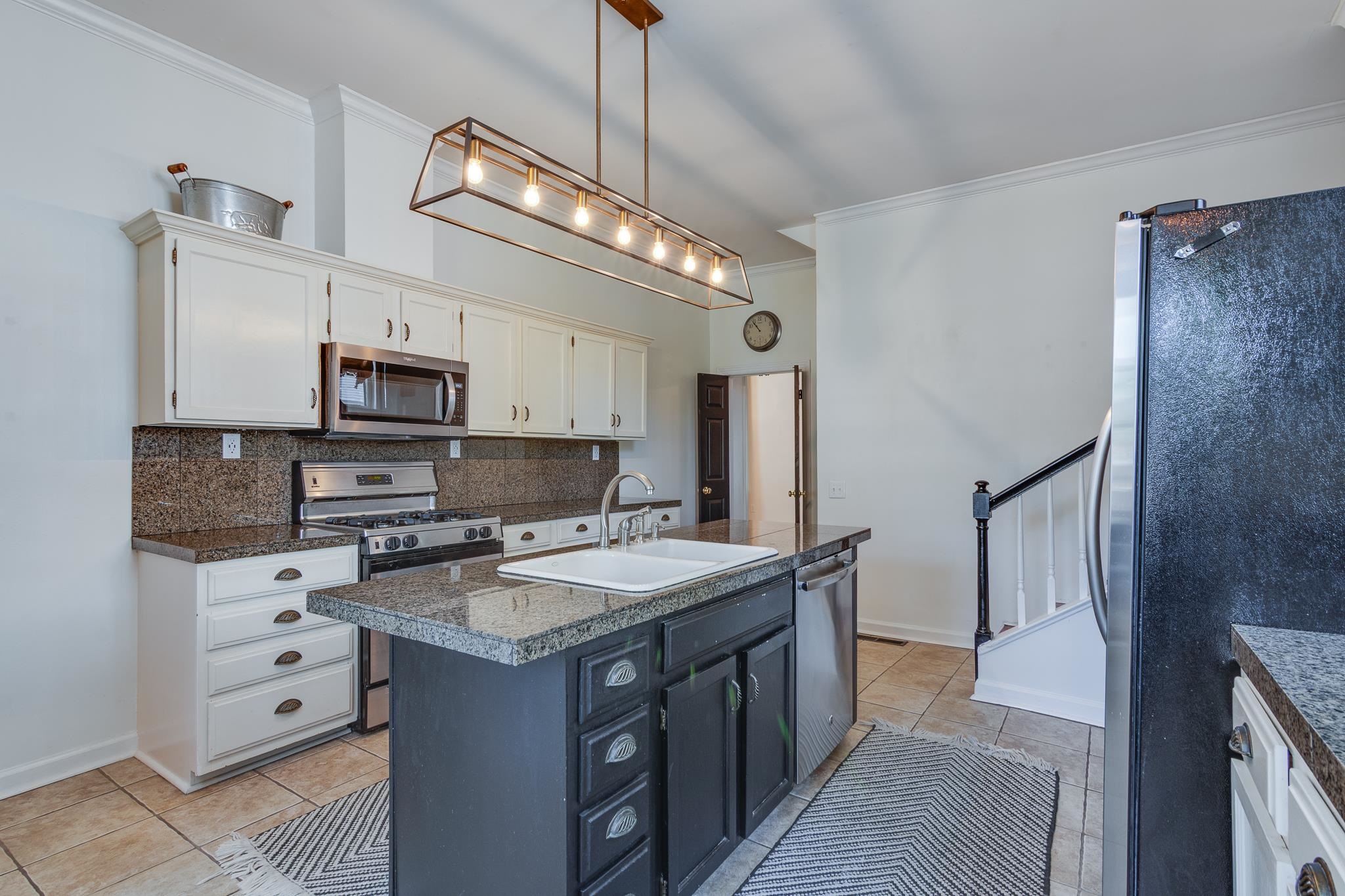 1680 Carruthers Place Memphis, TN 38112 - Photo 14 of 36 a kitchen with stainless steel appliances kitchen island granite countertop a refrigerator a stove a sink and dishwasher