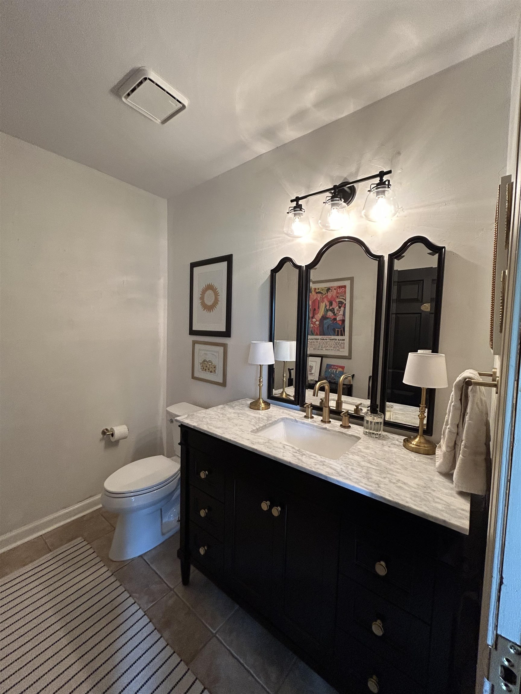 1680 Carruthers Place Memphis, TN 38112 - Photo 17 of 36 a bathroom with a double vanity sink toilet and a mirror