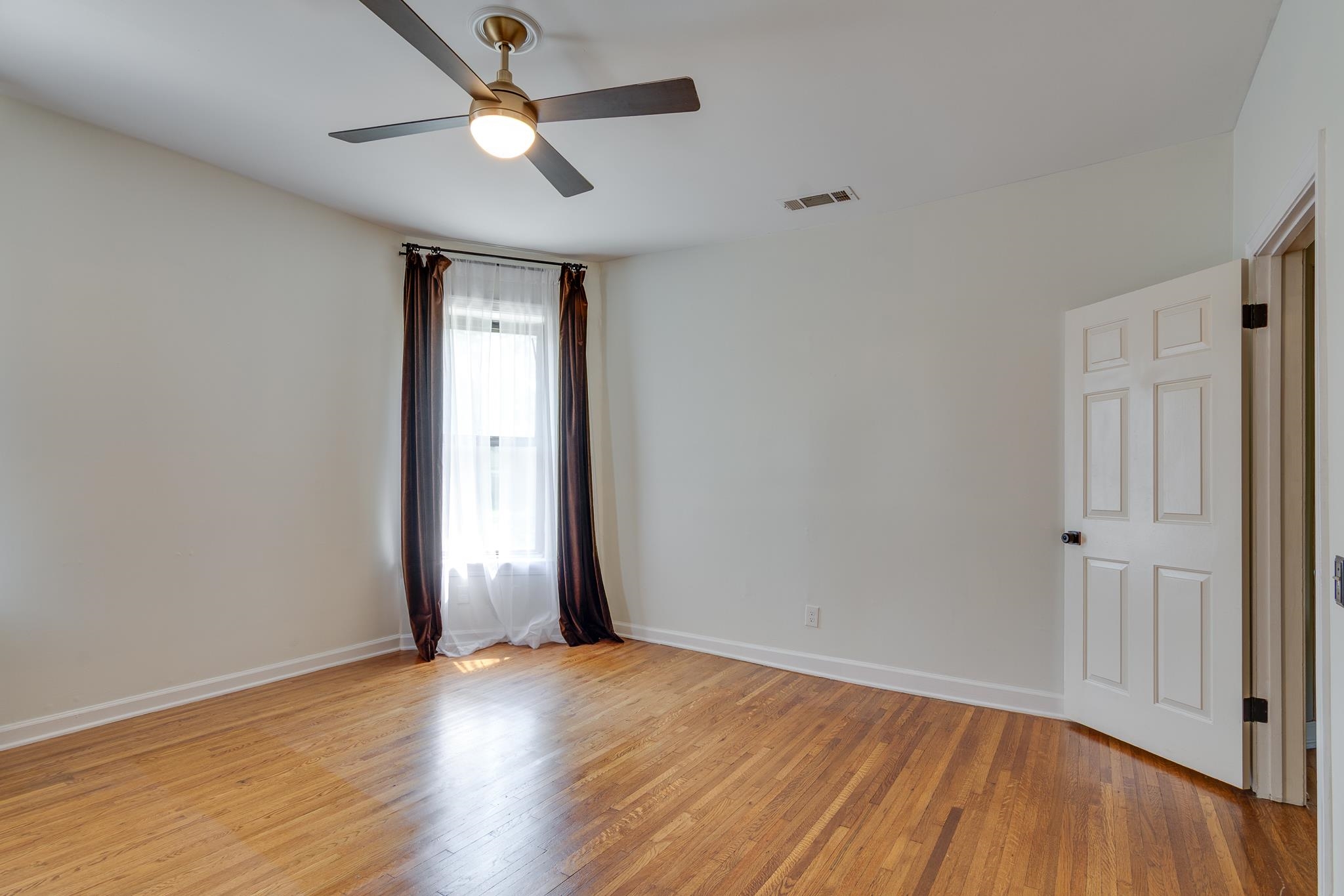 1680 Carruthers Place Memphis, TN 38112 - Photo 21 of 36 a view of empty room with wooden floor and fan