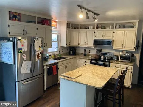 a kitchen with stainless steel appliances granite countertop a refrigerator stove a sink and a microwave