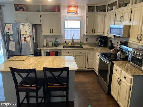 a kitchen with stainless steel appliances granite countertop a white cabinets and a stove top oven